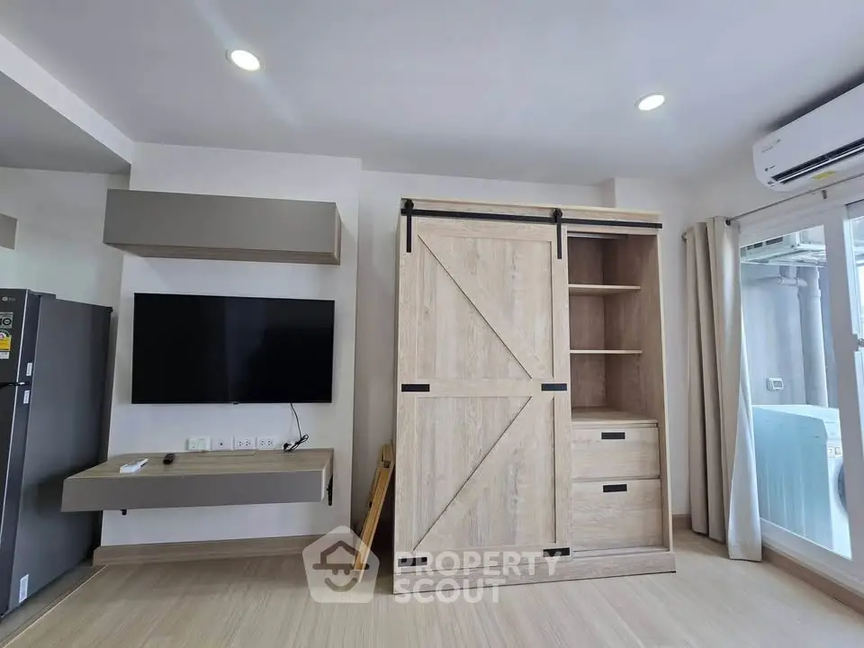 Modern living room with stylish wooden furniture and wall-mounted TV, featuring sleek air conditioning unit.