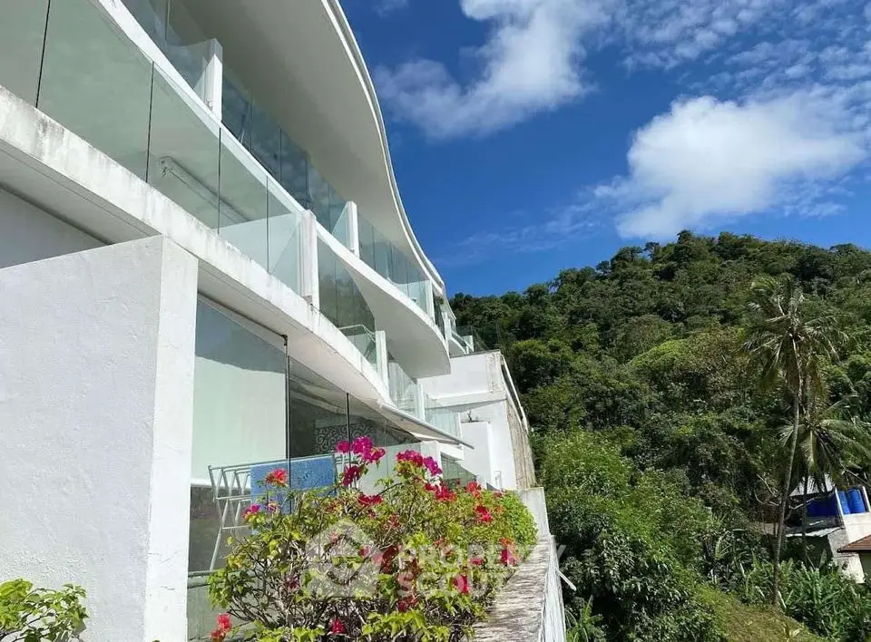 Luxurious modern hillside villa with glass balconies and lush greenery views