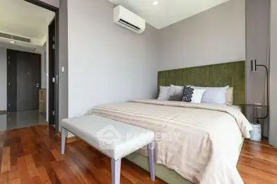 Spacious bedroom with modern decor and hardwood floors in a luxury apartment.