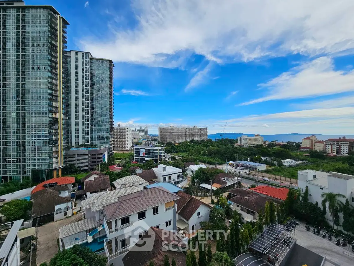 Stunning cityscape view with modern high-rise buildings and lush greenery under a vibrant blue sky.