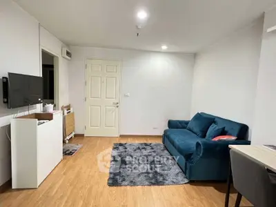 Cozy living room with modern blue sofa and wall-mounted TV, perfect for relaxation.
