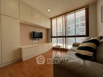 Modern living room with sleek design, large windows, and comfortable seating in a stylish apartment.