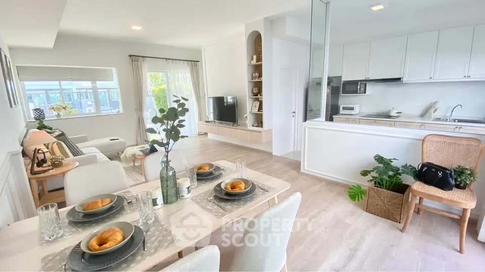 Spacious open-plan living and dining area with modern kitchen and elegant decor.