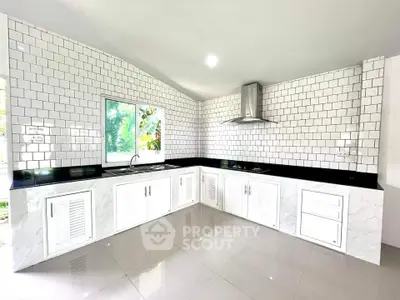 Modern kitchen with sleek white cabinets and glossy black countertops