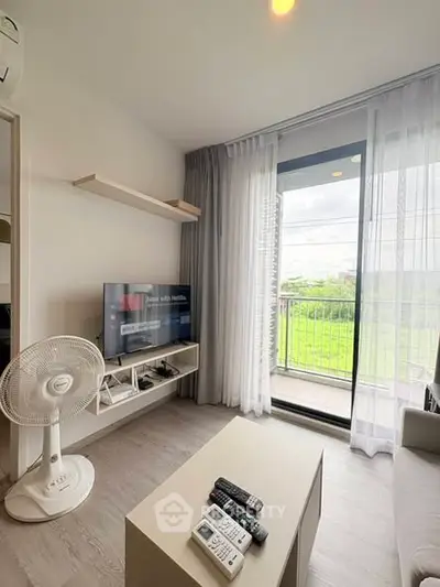 Modern living room with balcony view, featuring sleek furniture and natural light.