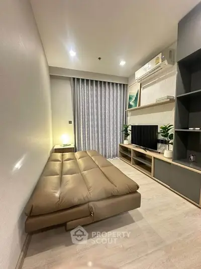 Modern living room with sleek furniture and cozy ambiance, featuring a stylish sofa and entertainment unit.