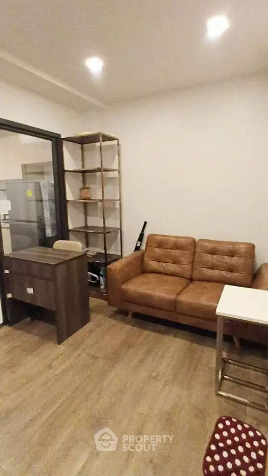 Modern living room with brown leather sofa and wooden furniture, ideal for cozy urban living.