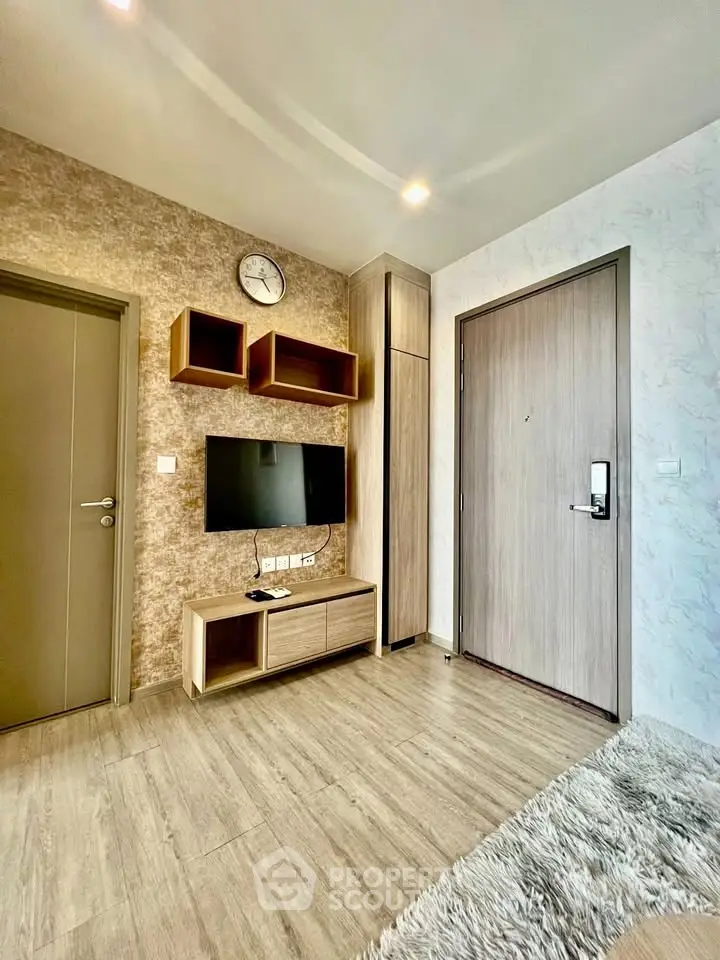 Modern living room with stylish decor and wall-mounted TV in a cozy apartment.