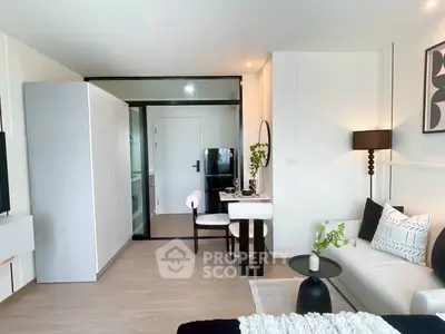 Modern living room with stylish decor and dining area, featuring sleek furniture and elegant lighting.