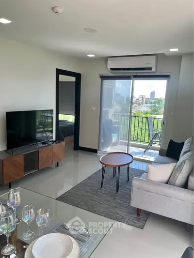 Modern living room with balcony view, stylish furniture, and natural light.