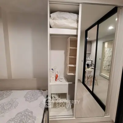 Modern bedroom with sliding wardrobe and mirrored doors, showcasing stylish interior design.