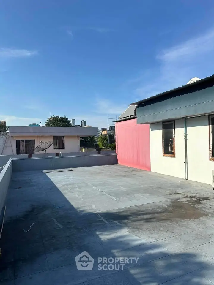 Spacious rooftop area with clear blue sky, ideal for outdoor activities and gatherings.