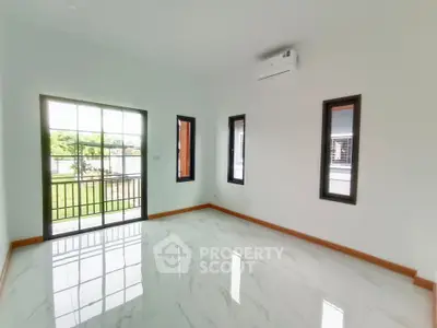 Spacious and bright living room with large windows and modern air conditioning unit.