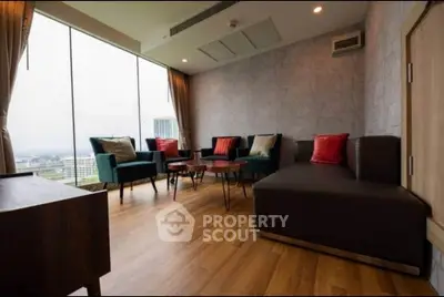 Spacious living room with modern furniture and panoramic city view.