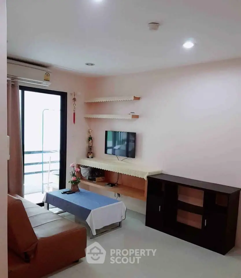 Cozy living room with modern decor and balcony access in a stylish apartment.