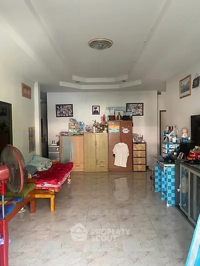 Spacious living room with tiled floor and ample storage options