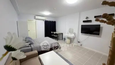 Modern studio apartment with cozy furnishings and wall-mounted TV