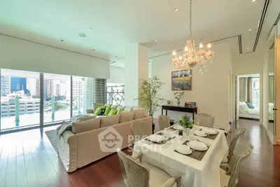 Luxurious open-plan living and dining area with elegant chandelier and city view.