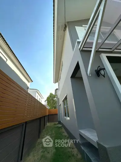 Modern two-story house exterior with sleek design and fenced yard