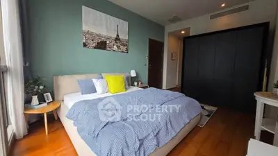 Spacious bedroom with stylish decor and large window offering natural light.