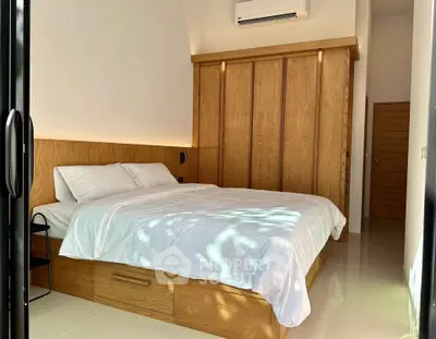 Modern bedroom with wooden accents and natural light, featuring a sleek air conditioning unit.