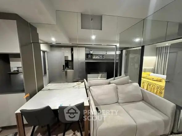 Modern open-plan living room with mirrored walls and cozy seating area