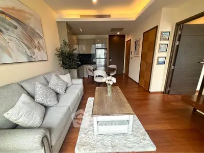 Modern living room with elegant decor and open kitchen layout in a stylish apartment.