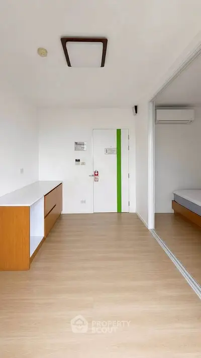 Modern minimalist bedroom with wooden flooring and sliding glass door