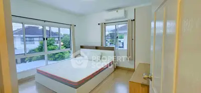 Bright and airy bedroom with large windows and modern furnishings in a serene neighborhood.