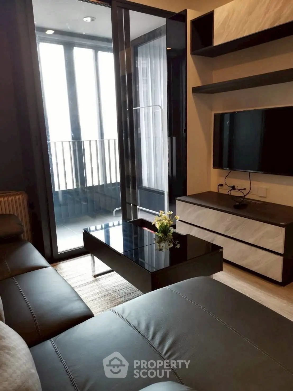 Modern living room with sleek furniture and balcony view in luxury apartment.