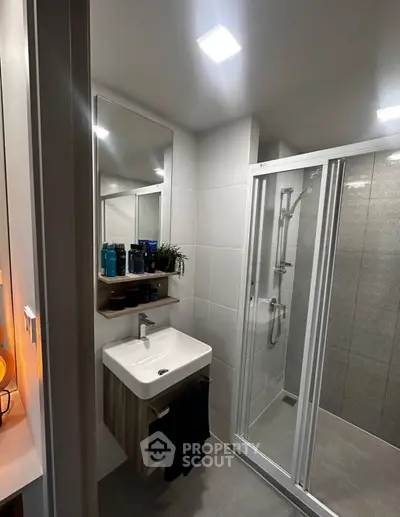Modern bathroom with sleek shower and stylish vanity in contemporary apartment.