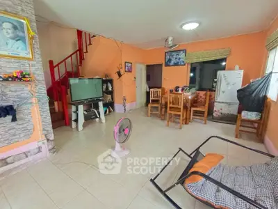 Spacious living room with dining area and staircase in cozy home