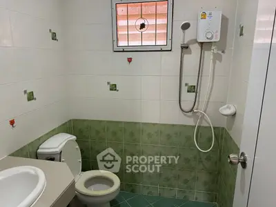 Cozy bathroom with shower and green tile accents