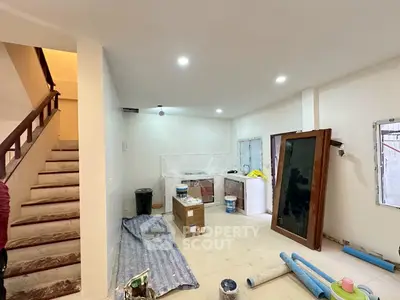 Spacious under-renovation living room with staircase, ideal for customization.