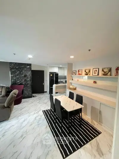 Modern open-plan living and dining area with stylish decor and marble flooring.