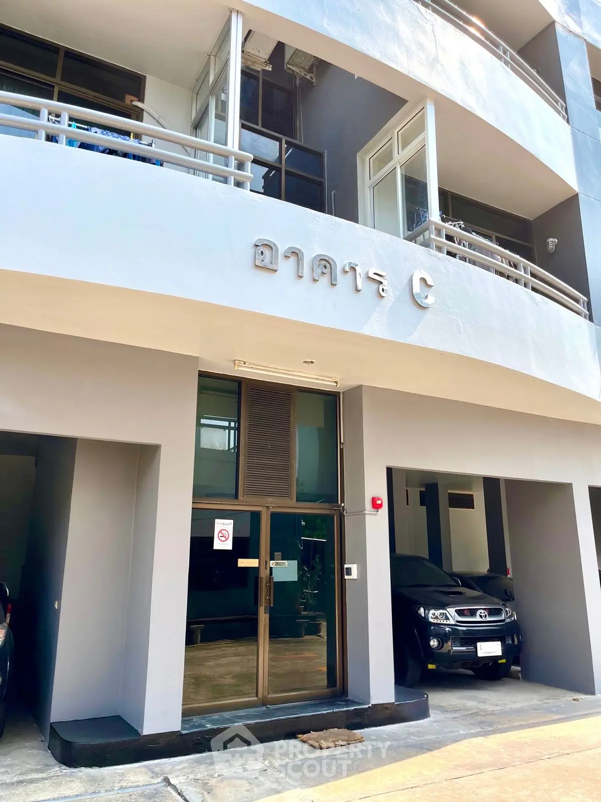 Modern apartment building entrance with parking and sleek design