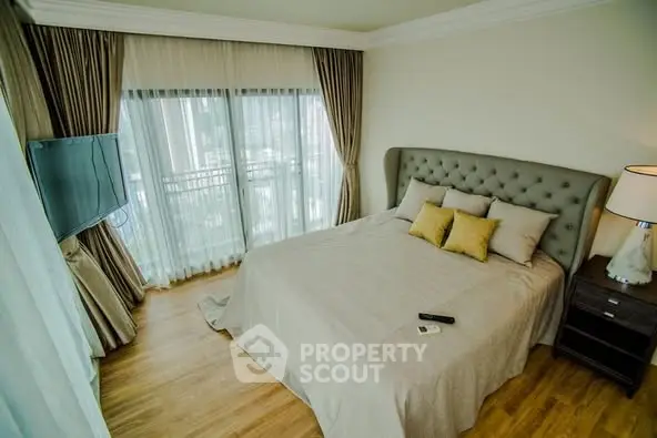 Luxurious bedroom with elegant decor and city view from large windows.