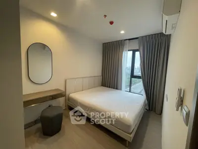 Modern bedroom with large window and minimalist decor in high-rise apartment.