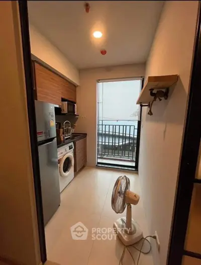 Compact kitchen with modern appliances and balcony view