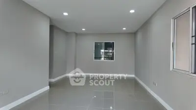 Spacious unfurnished room with tiled flooring and recessed lighting, ideal for customization.