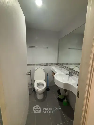 Modern bathroom with sleek fixtures and large mirror in a contemporary home.