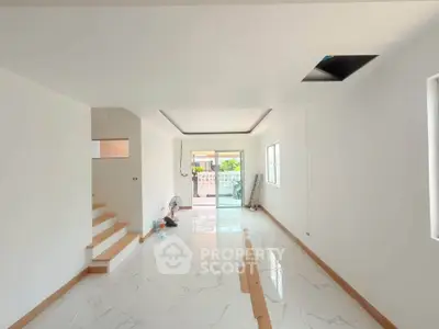Spacious modern living room with sleek marble flooring and large windows for natural light.