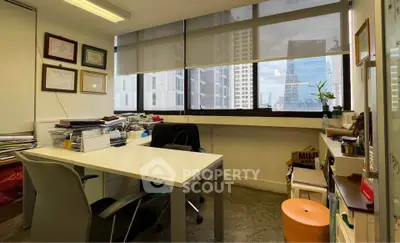 Modern office space with city view, featuring sleek furniture and ample natural light.