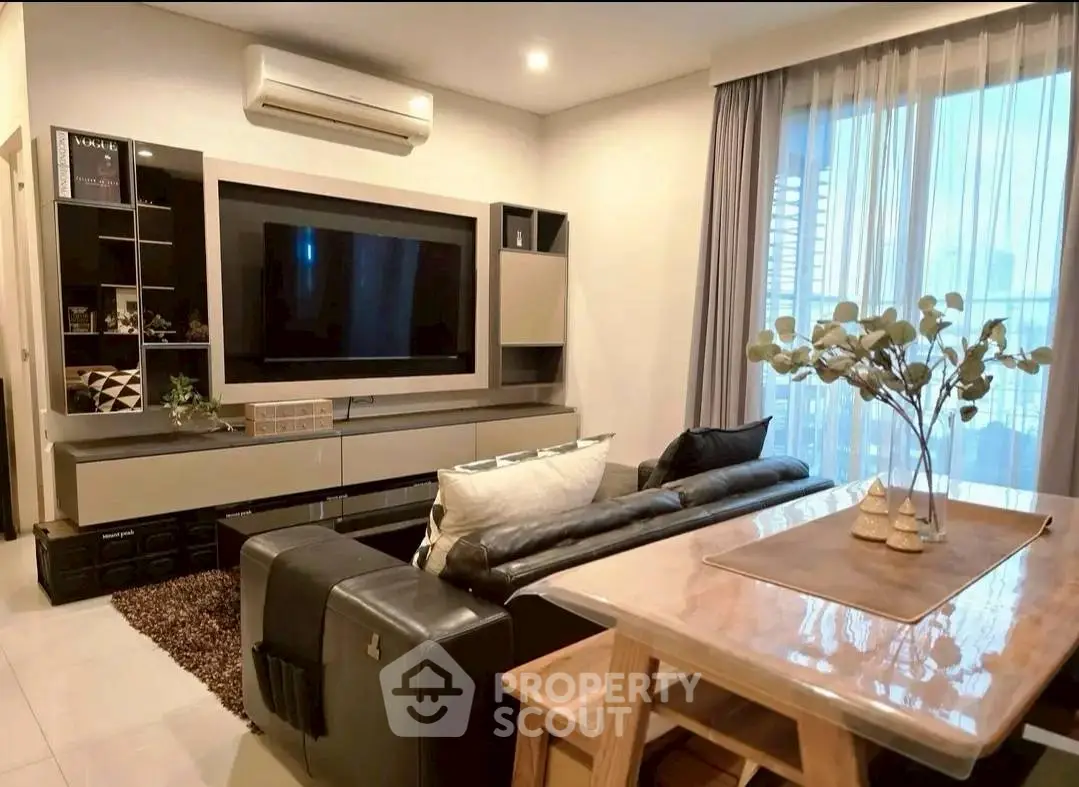 Modern living room with sleek furniture and large TV, perfect for relaxation.