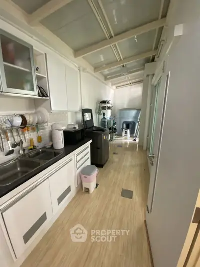 Compact kitchen with modern appliances and sleek cabinetry in a narrow layout.
