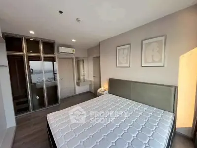 Spacious bedroom with modern decor and large windows offering natural light.