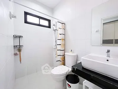Modern bathroom with sleek white tiles and contemporary fixtures.