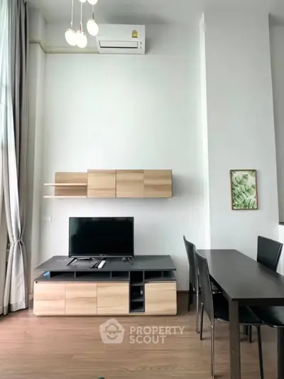Modern living room with sleek furniture and wall-mounted TV in a stylish apartment.