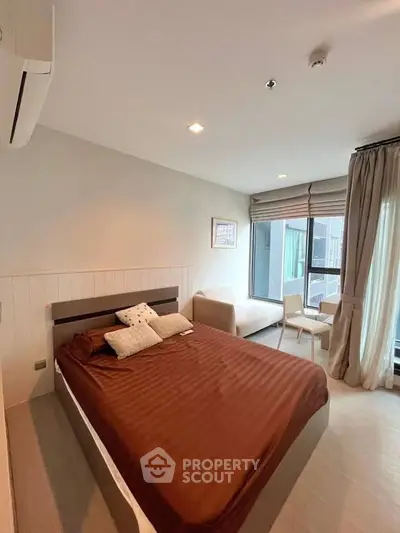 Modern bedroom with cozy bed and large window offering natural light