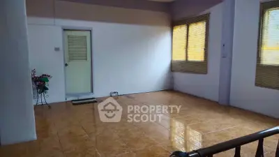 Spacious interior room with tiled flooring and large windows, perfect for versatile living space.